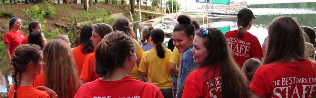 camp counselors with campers on the lake